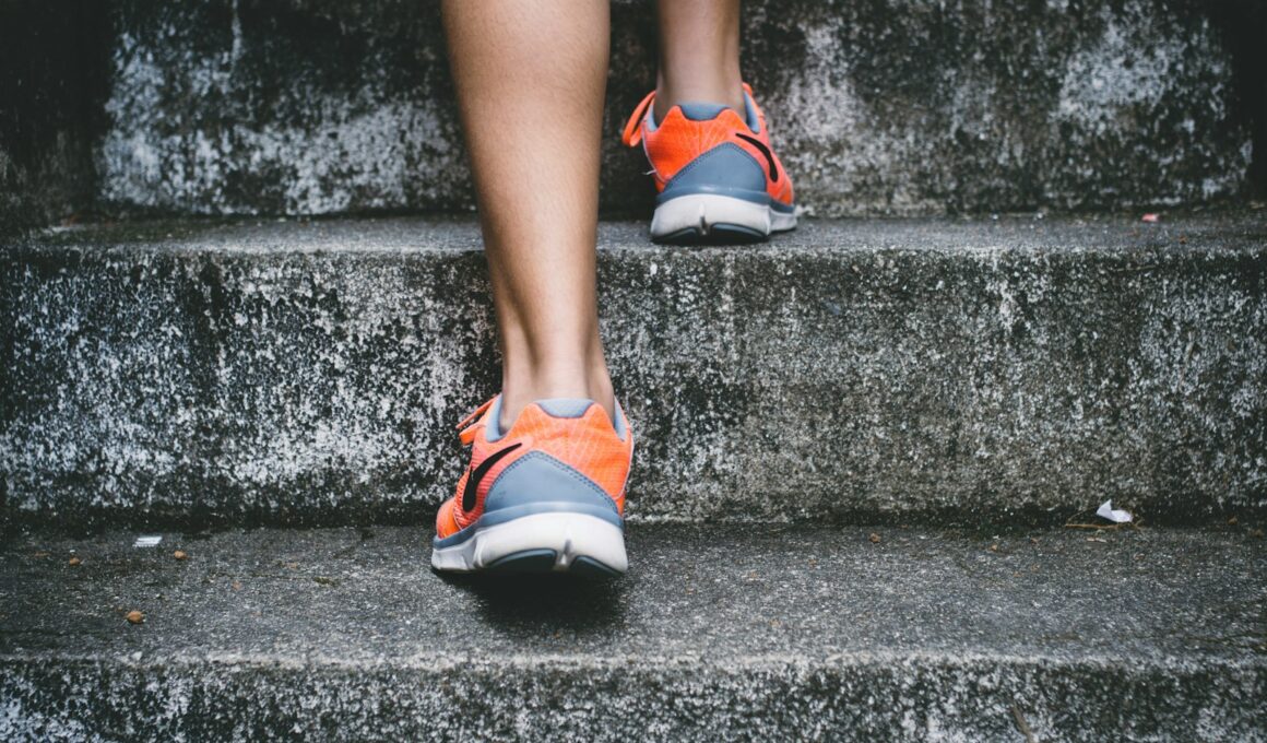 person wearing orange and gray Nike shoes walking on gray concrete stairs